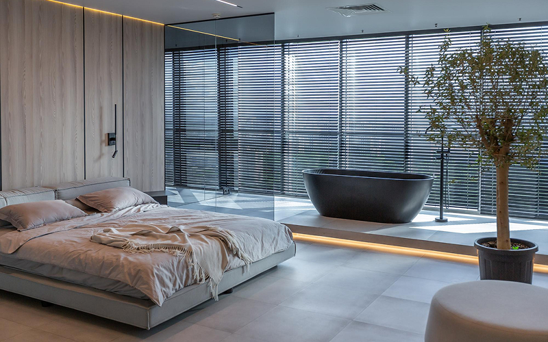 Modern venetian blinds in a luxury bedroom with bathtub.