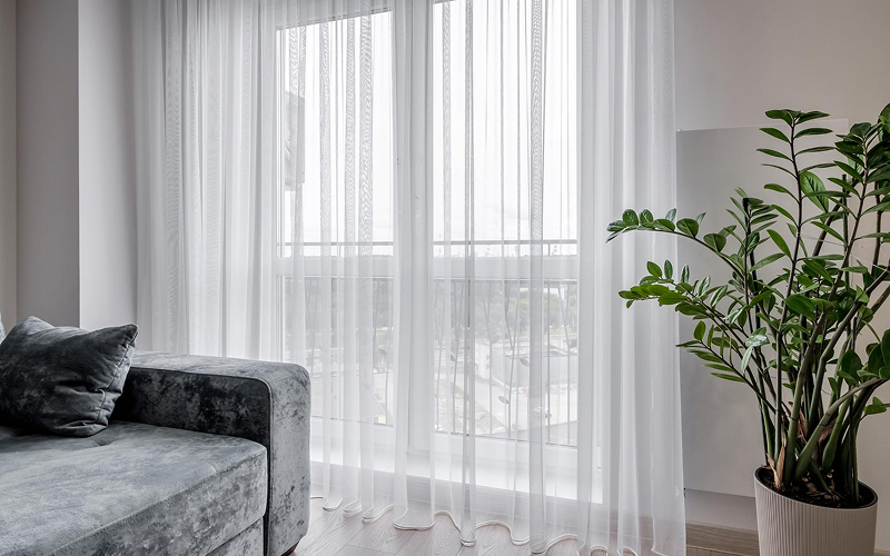 Sheer white day curtains for soft lighting in HDB flat.
