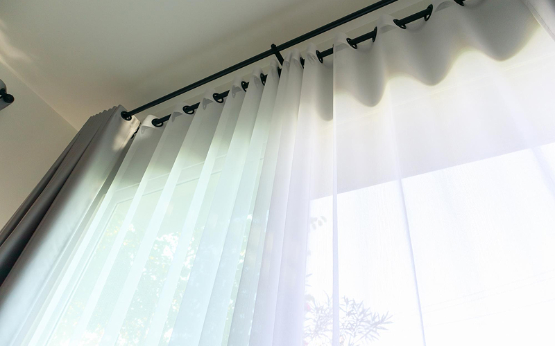 White grommet curtains hung on a modern black rod.
